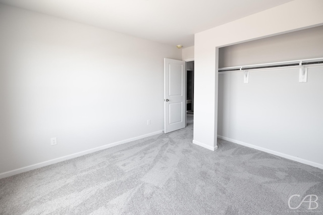 unfurnished bedroom with a closet and light colored carpet