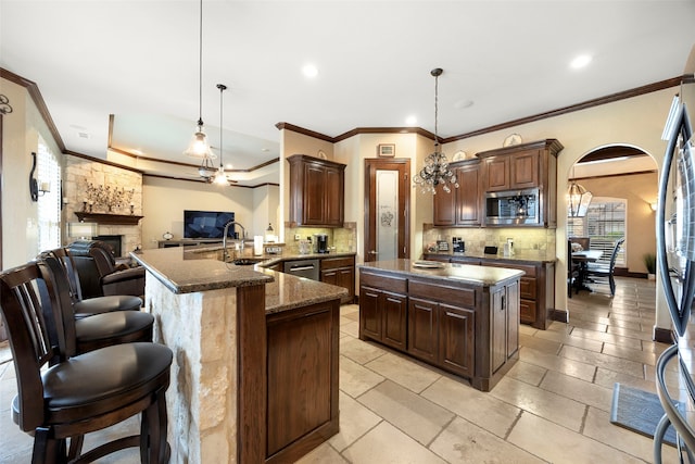 kitchen featuring stainless steel appliances, kitchen peninsula, a kitchen bar, and pendant lighting