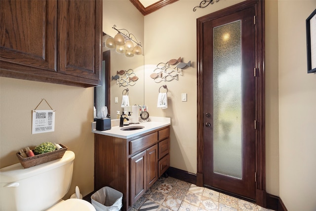 bathroom with vanity, toilet, and ornamental molding