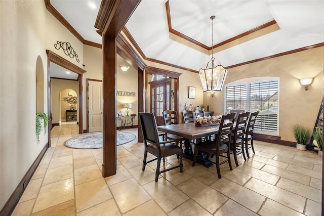 dining space with a towering ceiling, an inviting chandelier, and ornamental molding