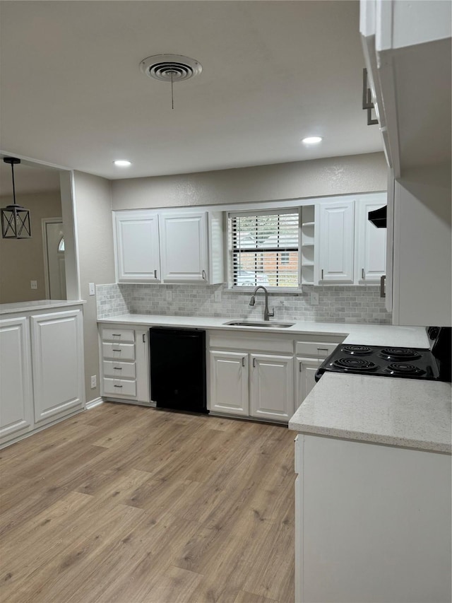 kitchen featuring white cabinetry, dishwasher, sink, hanging light fixtures, and light hardwood / wood-style floors