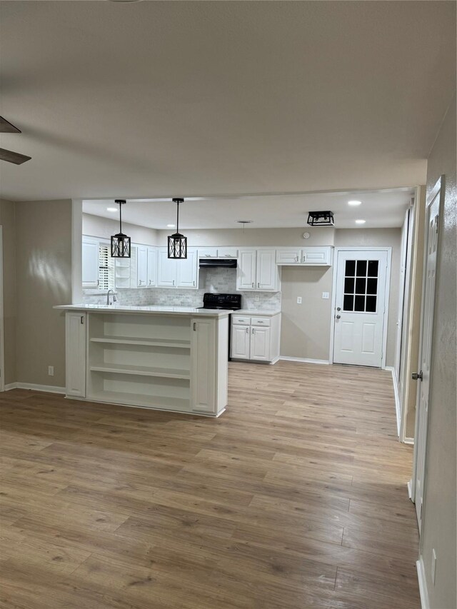 kitchen with white cabinetry, sink, pendant lighting, light hardwood / wood-style floors, and decorative backsplash