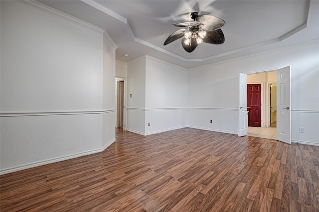 empty room with ceiling fan, light wood-type flooring, ornamental molding, and a tray ceiling