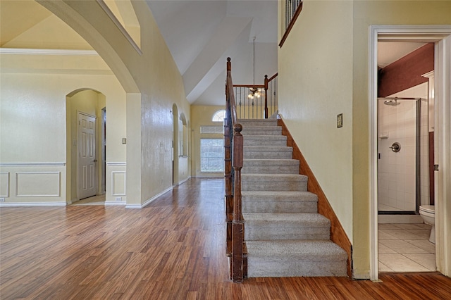 stairway featuring wood-type flooring and vaulted ceiling