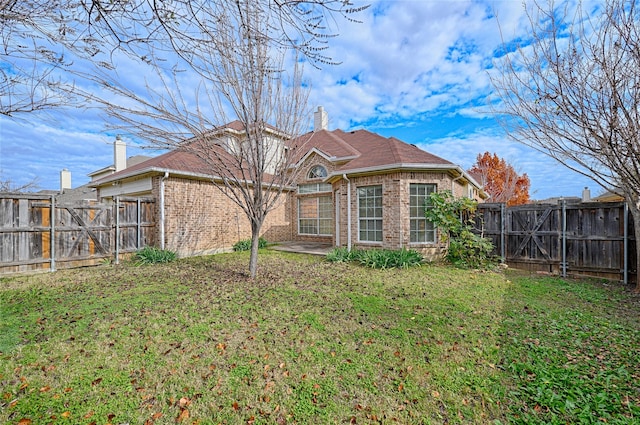 back of property featuring a yard and a patio