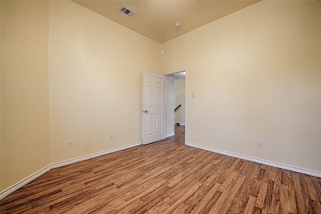 spare room with light hardwood / wood-style floors and lofted ceiling