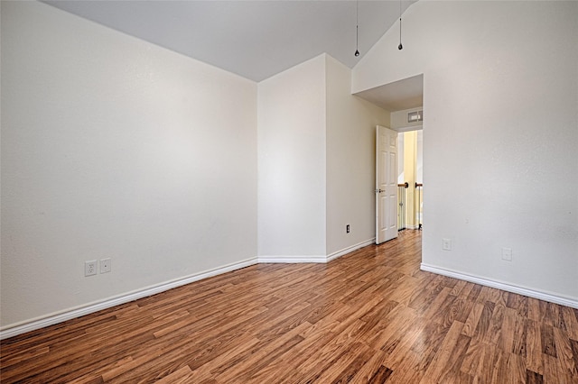 unfurnished room featuring hardwood / wood-style flooring and vaulted ceiling