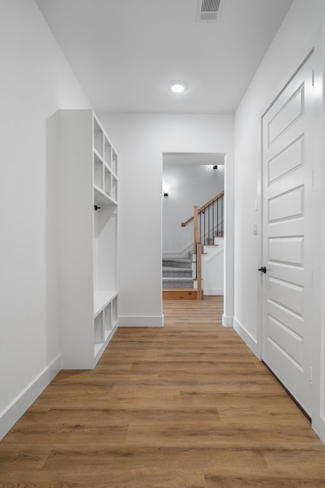 mudroom featuring wood-type flooring and built in features