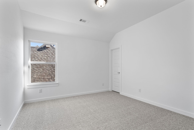 carpeted empty room featuring plenty of natural light and lofted ceiling