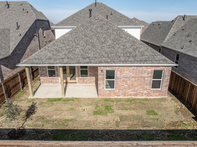 back of property featuring a patio area and a yard