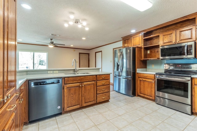 kitchen with appliances with stainless steel finishes, a textured ceiling, ceiling fan, crown molding, and sink