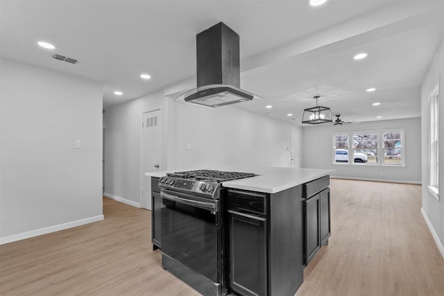 kitchen with pendant lighting, black range with gas stovetop, ceiling fan, a kitchen island, and island range hood