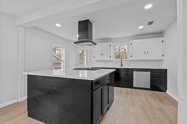 kitchen with a center island, light hardwood / wood-style flooring, island exhaust hood, white cabinets, and appliances with stainless steel finishes