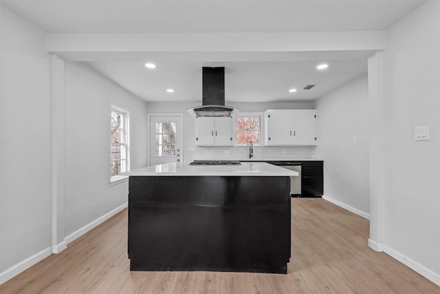 kitchen with a center island, white cabinetry, island exhaust hood, and tasteful backsplash