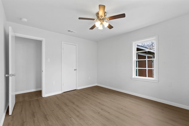 unfurnished bedroom with a closet, hardwood / wood-style flooring, and ceiling fan