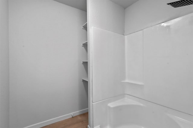 bathroom with a shower and hardwood / wood-style floors