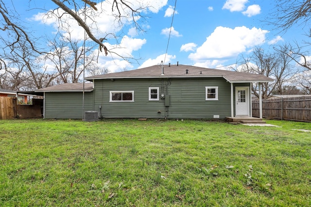 back of property featuring cooling unit and a lawn