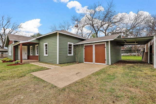 rear view of property featuring a carport, covered porch, and a lawn