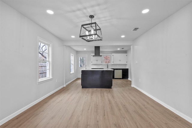 kitchen with stainless steel dishwasher, exhaust hood, white cabinets, a kitchen island, and hanging light fixtures