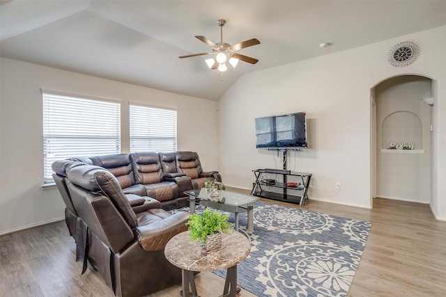 living room with hardwood / wood-style floors, ceiling fan, and vaulted ceiling