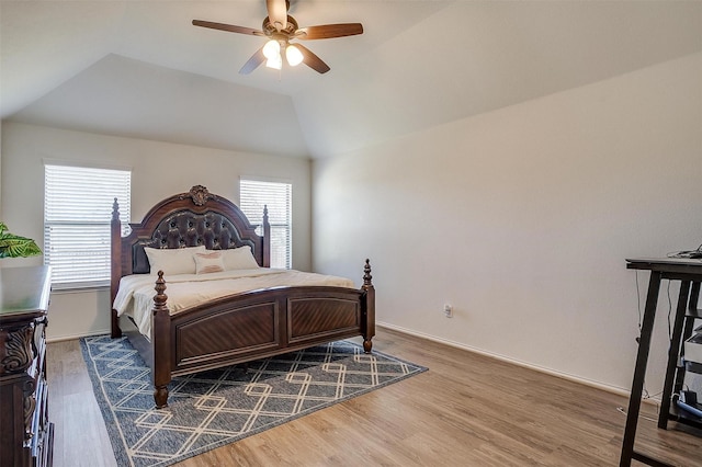 bedroom featuring multiple windows, wood-type flooring, vaulted ceiling, and ceiling fan