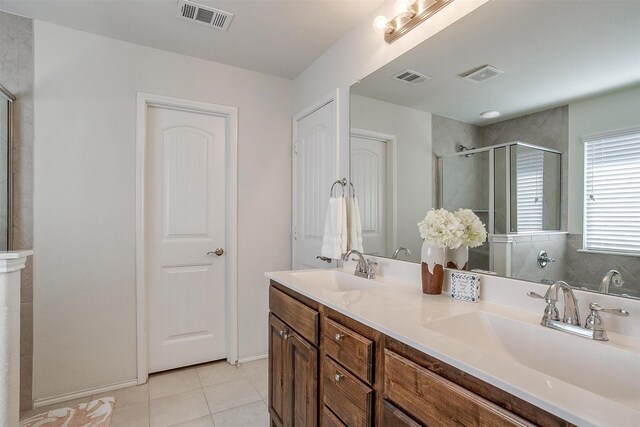 bathroom with tile patterned flooring, vanity, and an enclosed shower