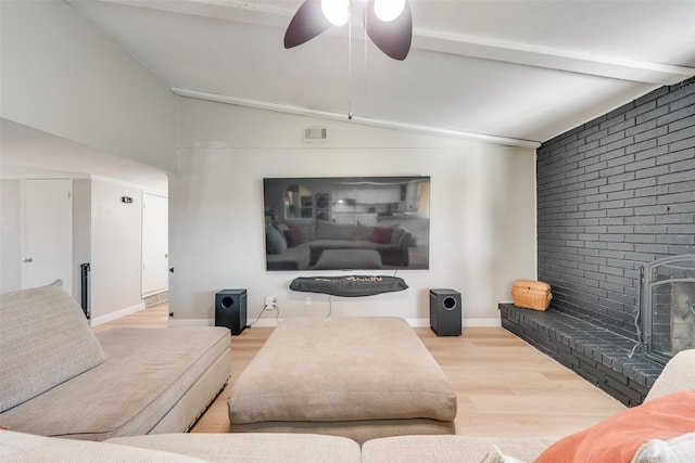 living room with wood-type flooring, a brick fireplace, vaulted ceiling with beams, and ceiling fan