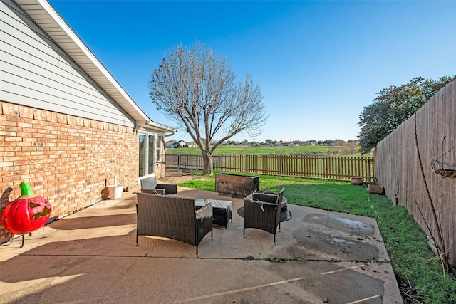 view of patio / terrace with a rural view, an outdoor living space, and a jacuzzi