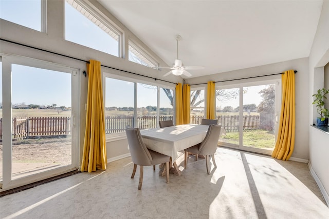 sunroom / solarium with lofted ceiling, ceiling fan, and a rural view