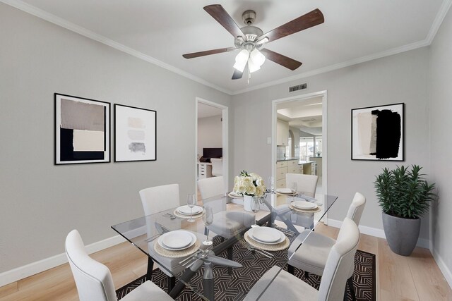 dining space featuring crown molding, ceiling fan, and light wood-type flooring