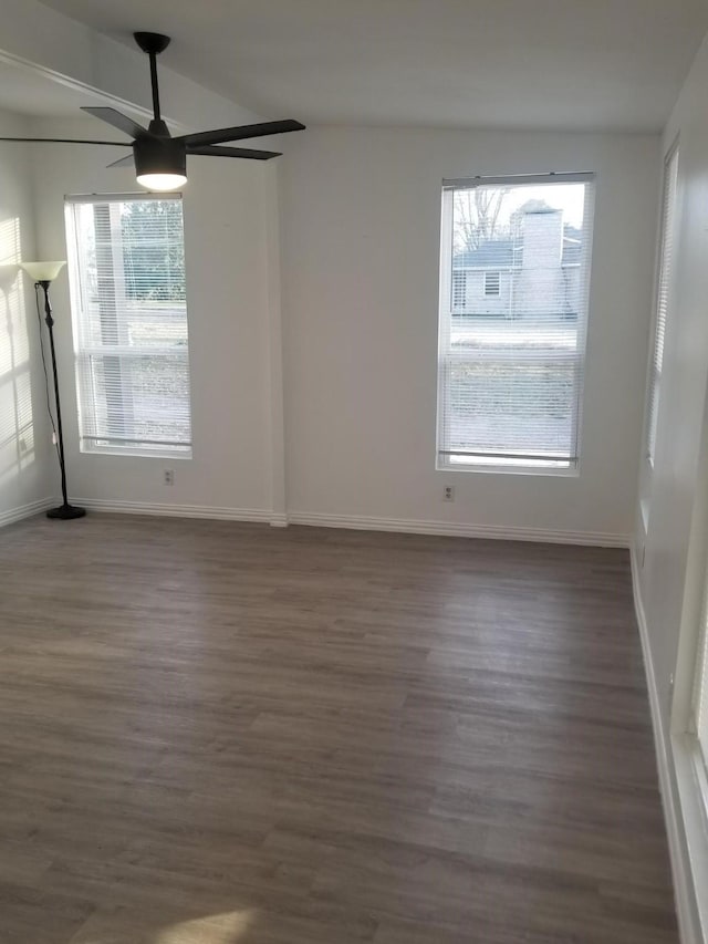 empty room with ceiling fan, dark hardwood / wood-style floors, and lofted ceiling