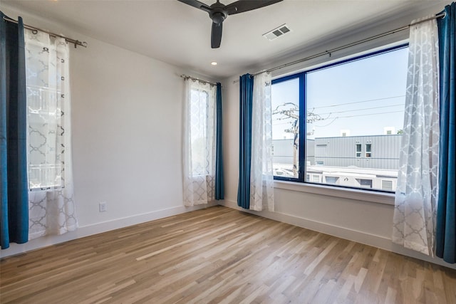 empty room with ceiling fan and light hardwood / wood-style floors