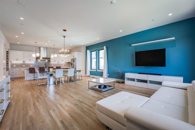 living room with light wood-type flooring and a chandelier