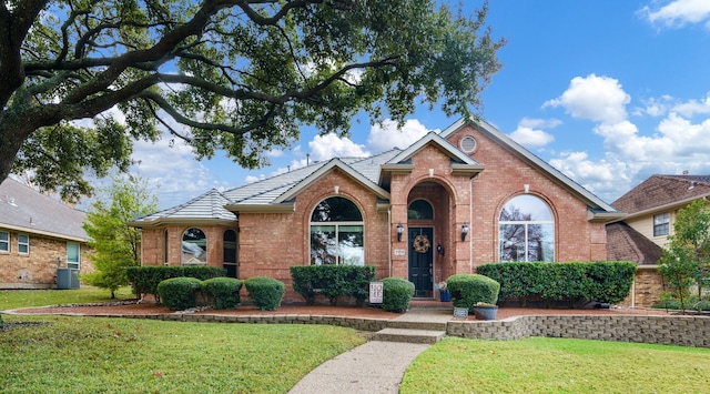 view of front of property featuring a front yard and central air condition unit