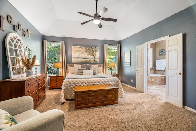 carpeted bedroom featuring multiple windows, ensuite bathroom, vaulted ceiling, and ceiling fan