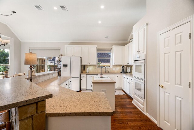 kitchen with white appliances, dark hardwood / wood-style floors, a kitchen island, and white cabinetry