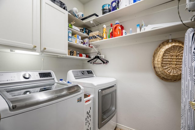 laundry room featuring separate washer and dryer and cabinets