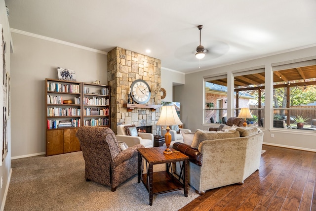 living room featuring ornamental molding, a stone fireplace, ceiling fan, and dark wood-type flooring