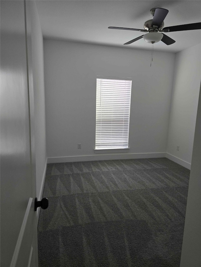 empty room featuring dark colored carpet and ceiling fan