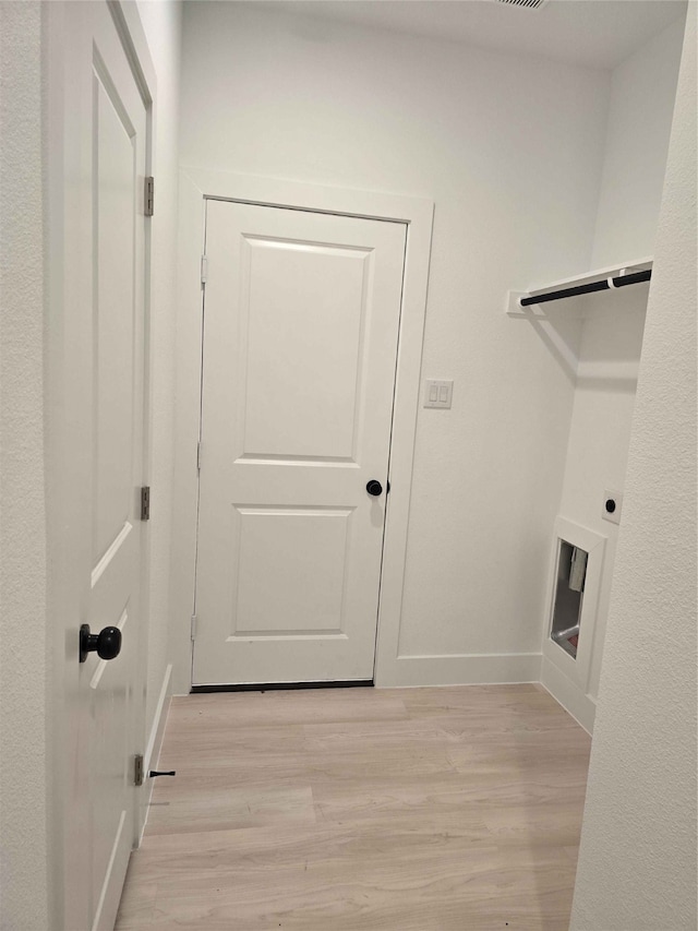 laundry area with light hardwood / wood-style flooring and hookup for an electric dryer