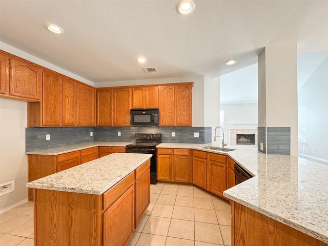 kitchen featuring sink, black appliances, light stone countertops, light tile patterned flooring, and kitchen peninsula