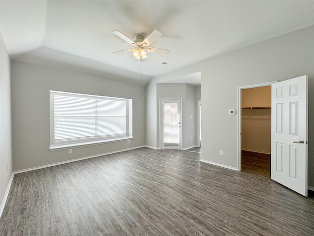 interior space with dark wood-type flooring, a spacious closet, vaulted ceiling, a closet, and ceiling fan