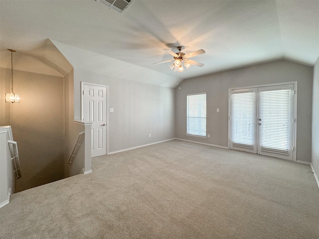 empty room featuring ceiling fan, lofted ceiling, and light carpet