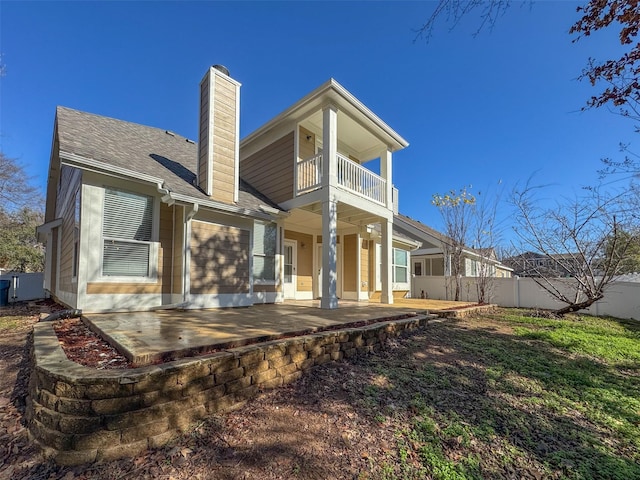 rear view of property with a patio and a balcony