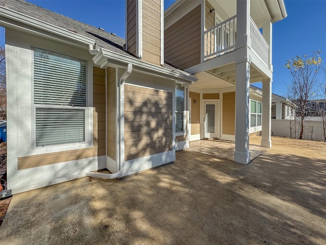 view of exterior entry featuring a balcony and a patio area