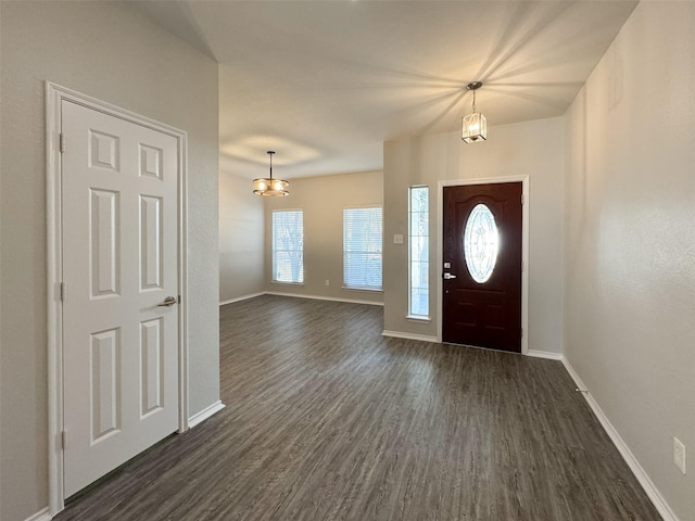 foyer with dark hardwood / wood-style flooring, a notable chandelier, and a healthy amount of sunlight