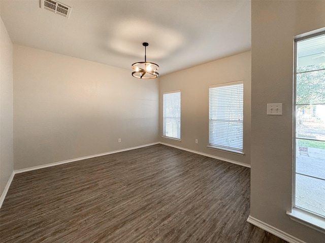 unfurnished room featuring plenty of natural light and dark hardwood / wood-style flooring