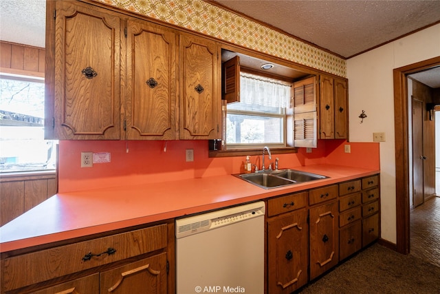 kitchen featuring dishwasher, light countertops, a sink, and brown cabinets