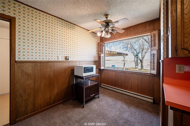 home office with wallpapered walls, wainscoting, carpet flooring, a textured ceiling, and a baseboard heating unit