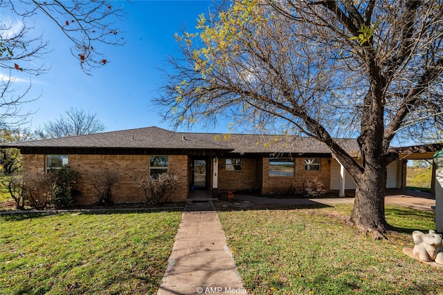 ranch-style house with brick siding, a front yard, and a shingled roof